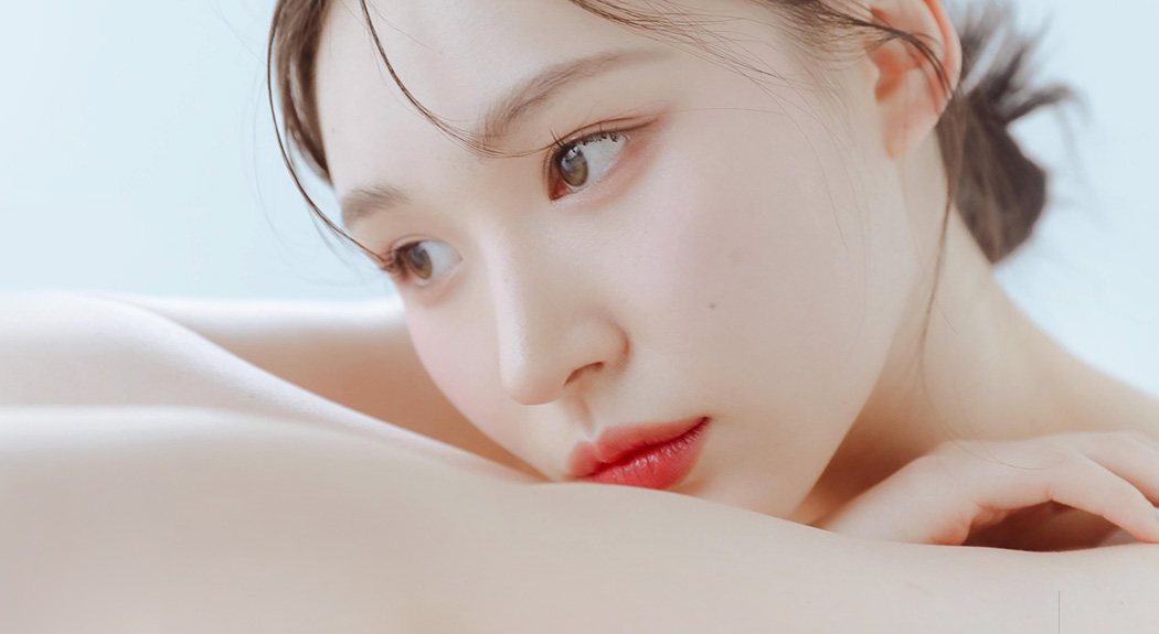 팔에 얼굴을 기대고 옆을 보는 여성 모델(옅은 하늘색 바탕)